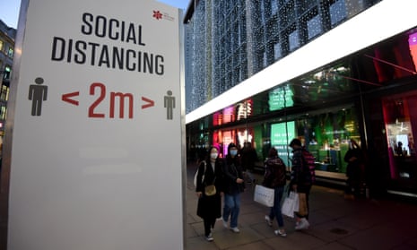  Shoppers walk past social distancing signs on Oxford Street.