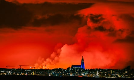 The skyline of Reykjavik against the backdrop of orange coloured sky due to molten lava flowing out from a fissure on the Reykjanes peninsula.