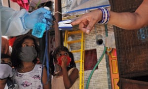A healthcare worker screens a resident of Dharavi for coronavirus in June.