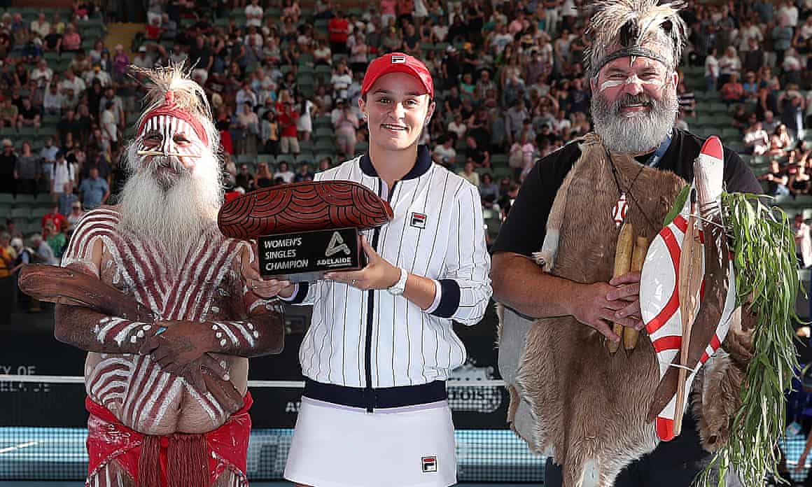 Ashleigh Barty of Australia poses with the trophy with Aboriginal elders Major Sumner and Mickey Kumatpi O’Brien