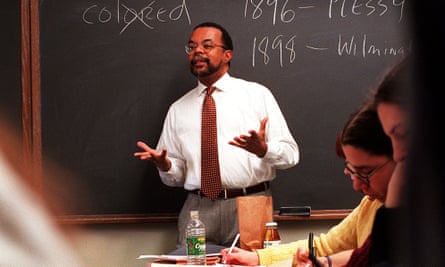 Gates standing in front of a blackboard talking to students