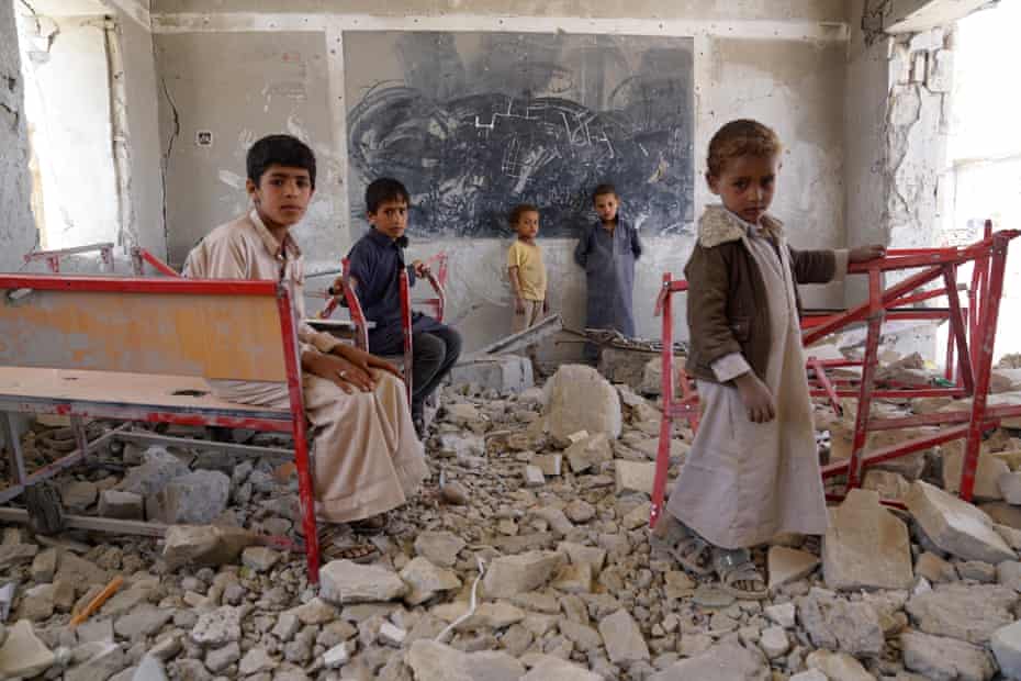 Young students in Sa’ada stand amid the ruins of a classroom destroyed in the Yemen conflict