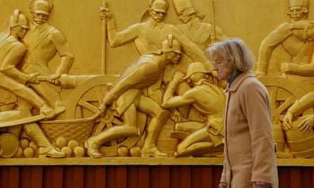 A woman walks past the bas-relief sculpture Suvorov soldiers in battle in Kherson