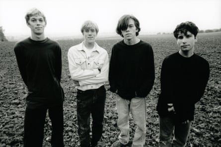 The four members of Ride looking moody in a field, in black and white