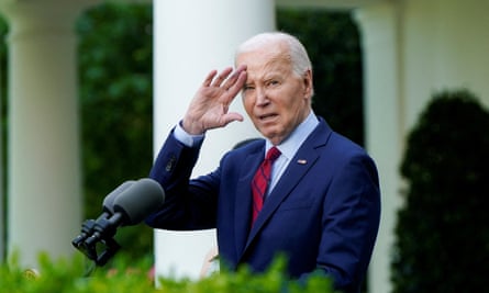 Man wearing navy suit and striped tie salutes in garden