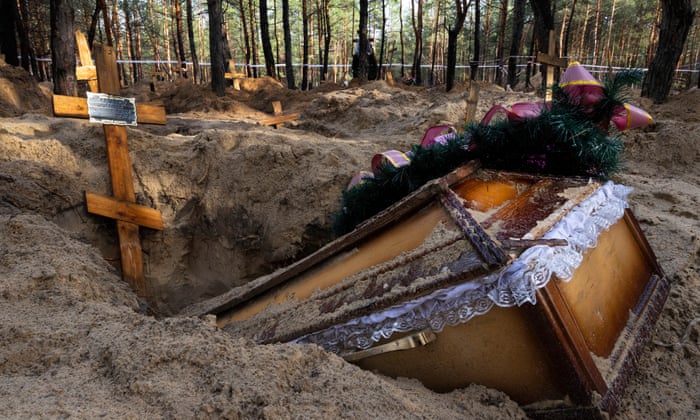 A coffin is seen at an unidentified makeshift grave at the Pishanske cemetery in Izium, Ukraine.