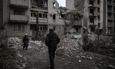 People walk amid damaged buildings s in Chasiv Yar, Donetsk oblast, in Ukraine on 28 November