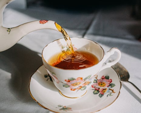 A vintage teapot pouring tea into a vintage teacup