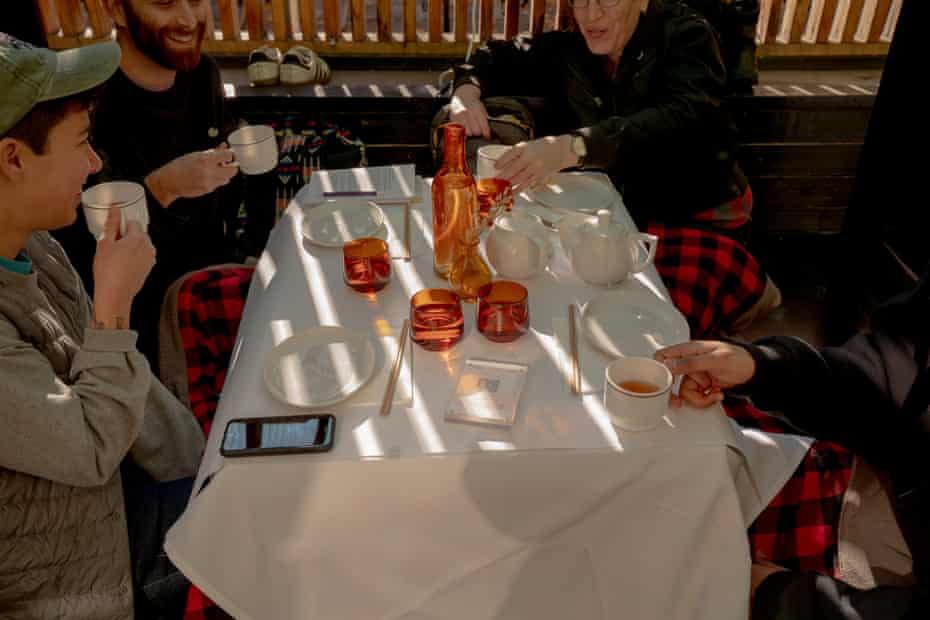 Close-up of a group of four people drinking in an outdoor dining establishment