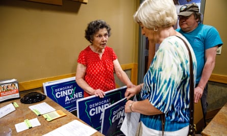Jan Lunde hands out yard signs to Carol Preston of during a town hall meeting for Iowa Democratic congressional candidate Cindy Axne.