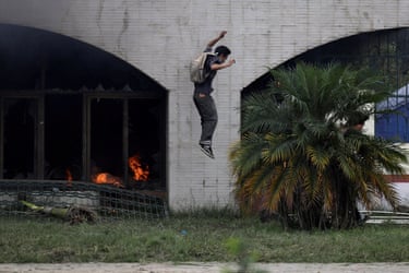 A person jumps a short height from a gate