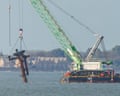 A crane barge lifts the rusted mast of the sunken SS Richard Montgomery from the water