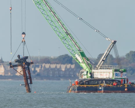 A crane barge lifts the rusted mast of the sunken SS Richard Montgomery from the water