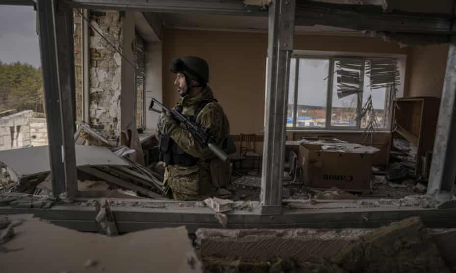A Ukrainian serviceman stands in a heavily damaged building in Stoyanka, Ukraine.