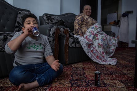 Emran, eight, drinks an energy drink at his house in Kabul.