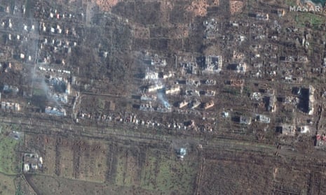 Satellite view of damaged apartment buildings and cratered fields from fighting.