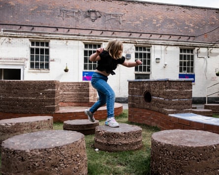 A young girl jumps from one round podium to another in a playground