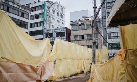 Yellow tarp and scaffoldings cover the area where demolition of old buildings is in progress, Euljiro, Seoul.