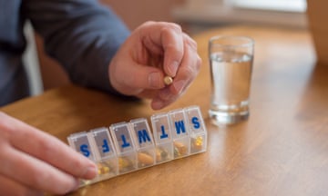 Man taking daily supplements from plastic pill organiser