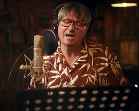 a man with headphones reads a poem into a microphone