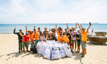 Travellers on Intrepid Travel’s Peloton Against Plastic cycling tour take part in a beach clean up in Hoi An, Vietnam.