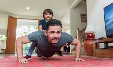Father doing pushups with son on back