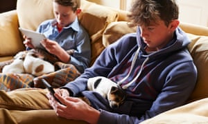 two boys on a sofa on devices