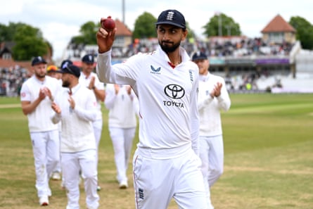 England’s Shoaib Bashir holds up a cricket ball to fans.