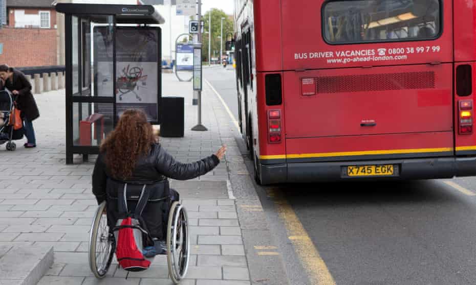 A wheelchair user hailing a bus.