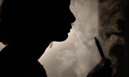A person poses for a photograph as they vape in Melbourne