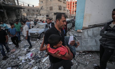 Israel-Hamas war live: White House promises ‘continued flow’ of Gaza aid as Israel steps up airstrikes in north of strip | Israel-Hamas war 12 A man carries a rescued child as search and rescue efforts continue after an Israeli airstrike in Khan Yunis, Gaza on Saturday.