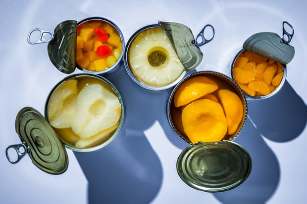 Fruit in opened tin cans: pears, pineapples, peaches, tangerines.