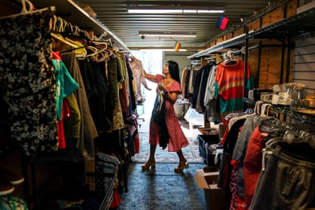 A woman organizes clothes in a shop