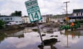 A flooded street in a Vermont town with a Highway 14 sign sticking out of the water.