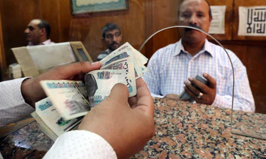 An employee counts Egyptian pounds in a bank in Cairo