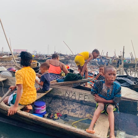 ‘They told us to leave. They didn’t tell us where to go’: the demolitions destroying homes and lives in Lagos Women and children sitting in boats surrounded by debris from demolished houses.