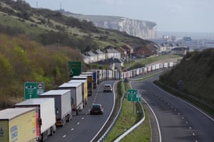 A long queue of lorries wait as with the white cliffs of Dover in the distance