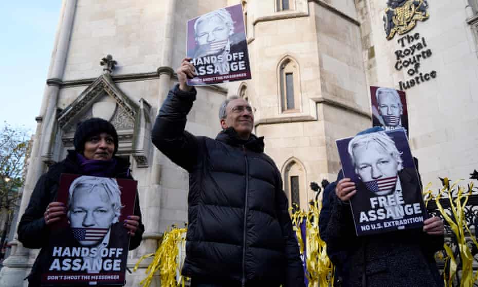 Supporters of Julian Assange hold placards outside the Royal Courts of Justice in London.