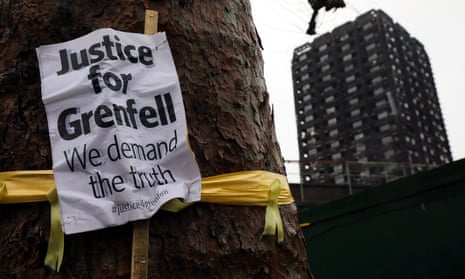A ‘Justice for Grenfell’ sign hangs on a tree near the tower.