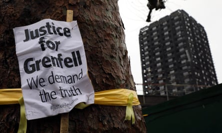 A ‘Justice for Grenfell’ sign hangs on a tree near Grenfell Tower
