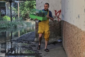 A local man rescues cats from a flooded building in Kherson.