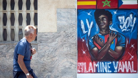 A man walks past a graffiti depicting Lamine Yamal in Rocafonda.