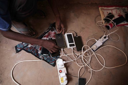 A person checks several mobile phones plugged into one charger