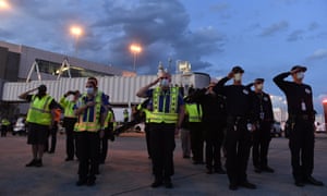 Transportation Security Administration agents and Denver paramedics salute as the casket carrying the body of retired paramedic Paul Cary arrives at Denver International Airport on Sunday.