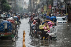 Dhaka, Bangladesh: Rickshaws are pulled through a waterlogged street along with their passengers after a heavy downpour.