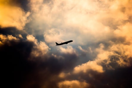 A silhouette of an airplane in the clouds