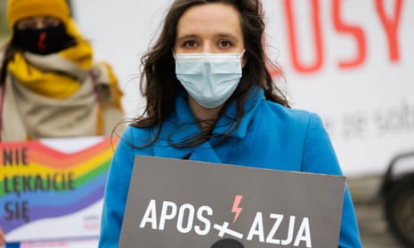 A woman hold a poster urging people to commit formal acts of apostasy to renounce their faith.