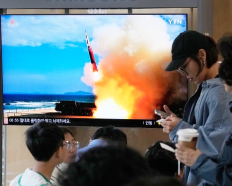 People stand near a TV screen showing a file image of a North Korean missile launch during a news program at Seoul railway station on Saturday