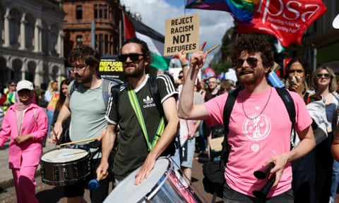 People marching with those in front banging drums qhiddtitxidinv