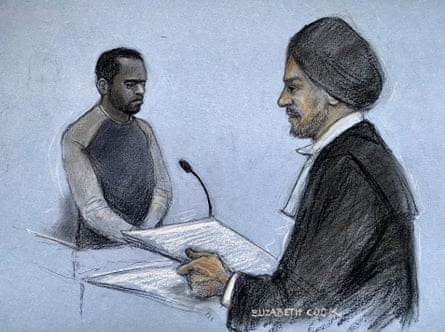 Man at mic looking down and barrister